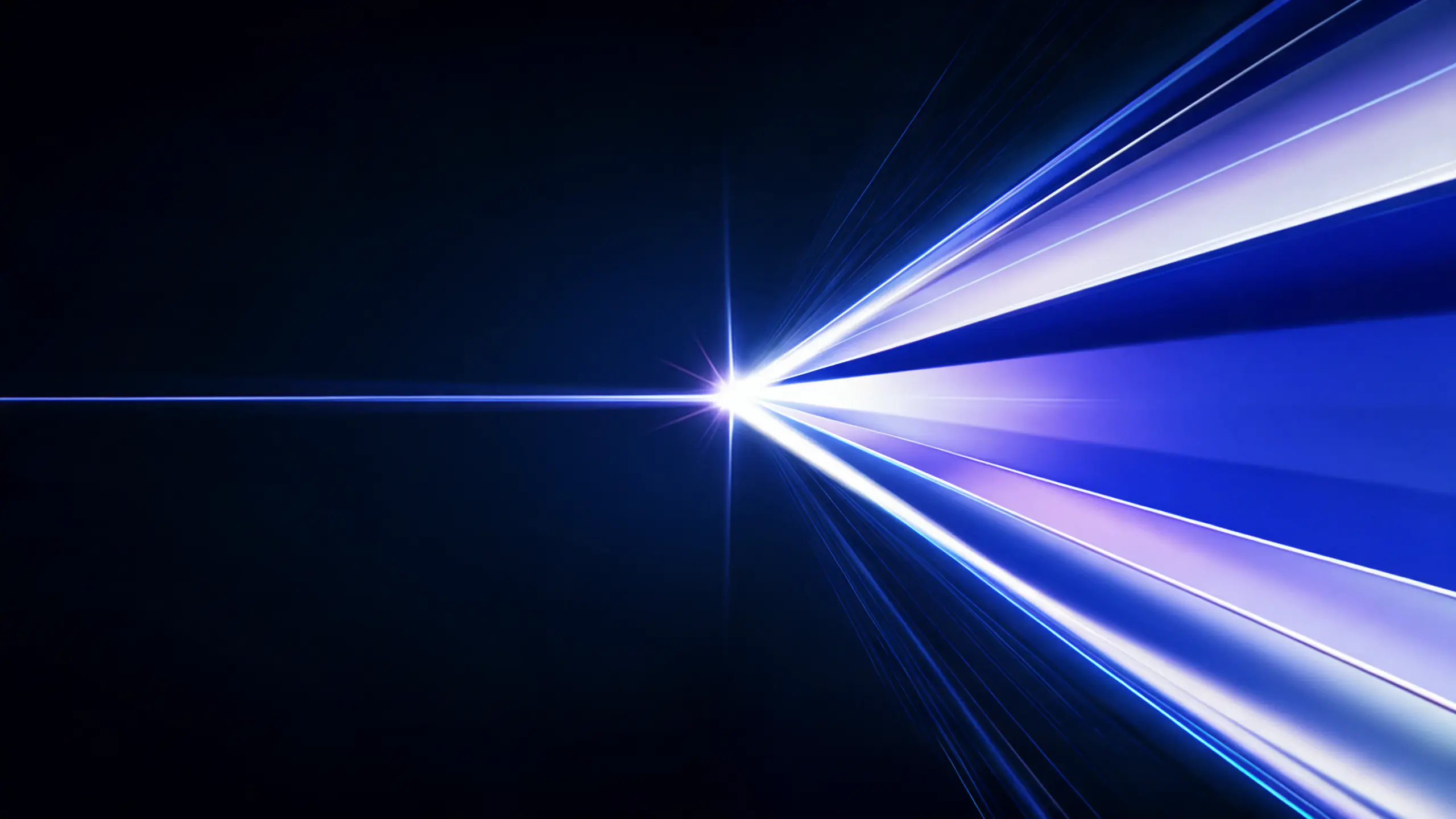 A beam of light on a dark background fanning out into blue and violet rays